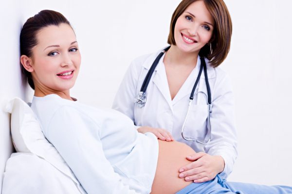 Doctor touches the belly of a pregnant woman